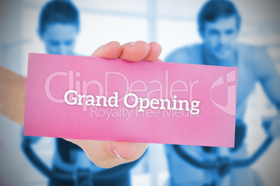 Woman holding pink card saying grand opening