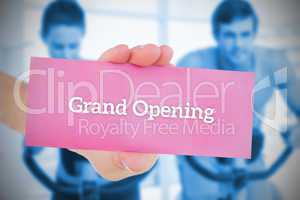 Woman holding pink card saying grand opening