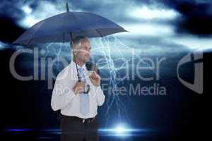 Composite image of happy businessman holding umbrella