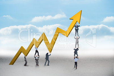 Composite image of business team holding up arrow