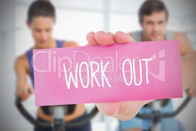 Woman holding pink card saying work out
