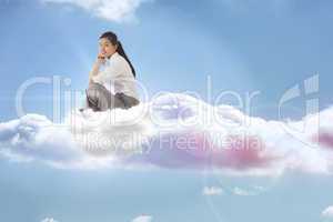 Composite image of businesswoman sitting cross legged with hands