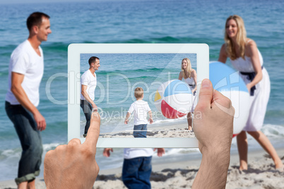 Composite image of hand holding tablet pc