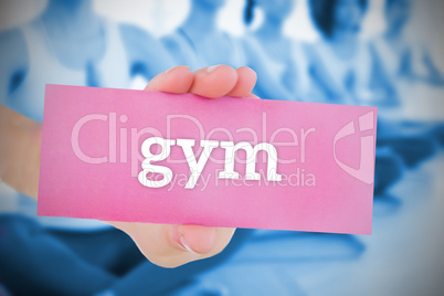 Woman holding pink card saying gym Woman holding pink card saying gym