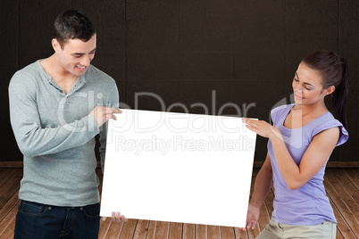 Composite image of attractive young couple showing card