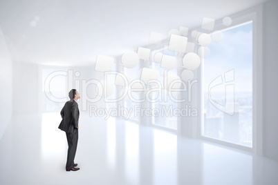 Composite image of serious businessman with hands on hips