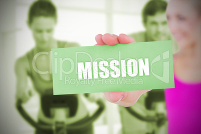 Fit blonde holding card saying mission