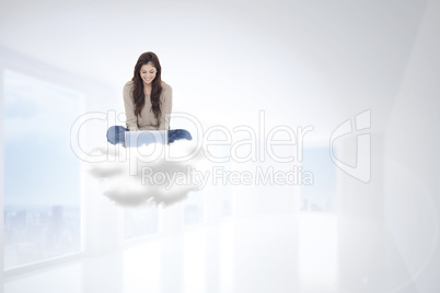 Composite image of brunette sitting on cloud using laptop