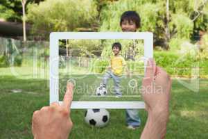 Composite image of hand holding tablet pc