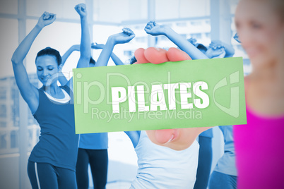 Fit blonde holding card saying pilates