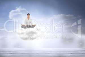 Composite image of businesswoman sitting in lotus pose