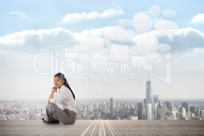 Composite image of businesswoman sitting cross legged with hands