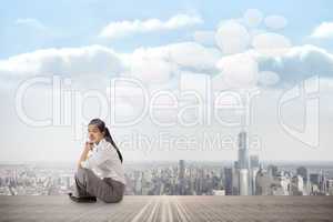 Composite image of businesswoman sitting cross legged with hands