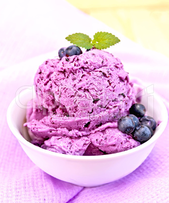 Ice cream blueberry with mint in bowl on purple napkin