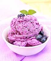 Ice cream blueberry with mint in bowl on purple napkin