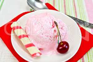 Ice cream cherry on red paper napkin with spoon