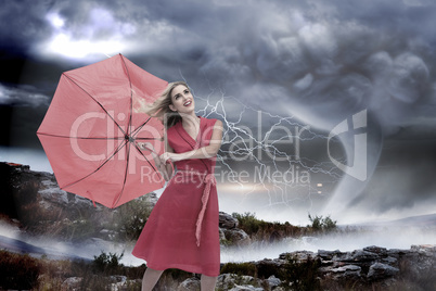 Composite image of elegant blonde holding umbrella