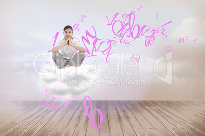 Composite image of businesswoman sitting cross legged with hands