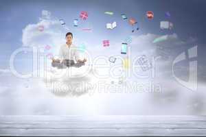 Composite image of businesswoman sitting in lotus pose