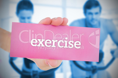 Woman holding pink card saying exercise