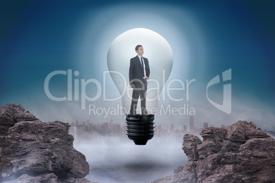 Composite image of thinking businessman in light bulb