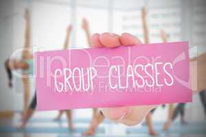 Woman holding pink card saying group classes