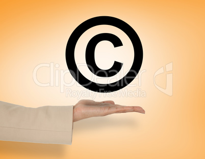 Composite image of female hand presenting copyright symbol