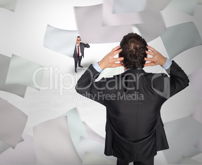 Composite image of stressed businessman with hands on head with