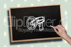 Composite image of hand drawing megaphone with chalk