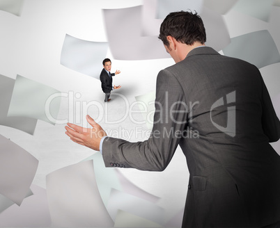 Composite image of businessman posing with hands out with tiny b