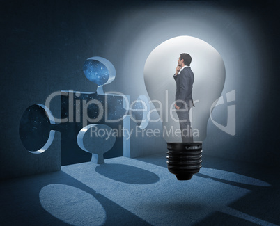 Composite image of thinking businessman in light bulb