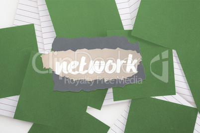 Network against green paper strewn over notepad