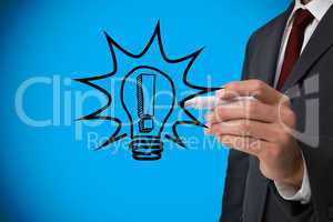 Composite image of businessman drawing light bulb