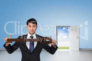 Composite image of unsmiling businessman carrying large key