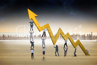 Composite image of business team holding up arrow