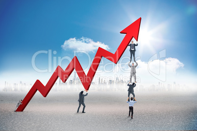 Composite image of business team holding up arrow