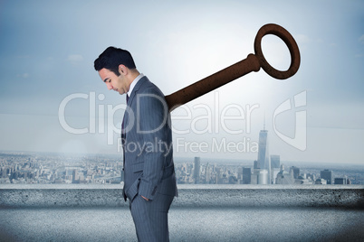 Composite image of wound up businessman with hands in pockets