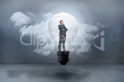 Composite image of thinking businessman in light bulb