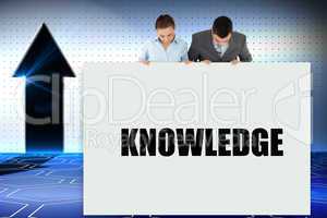Business partners showing card saying knowledge