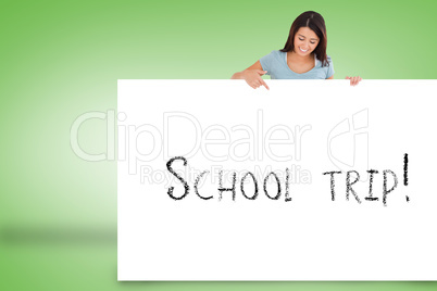Pretty brunette showing card with school trip