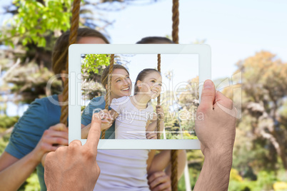 Composite image of hand holding tablet pc