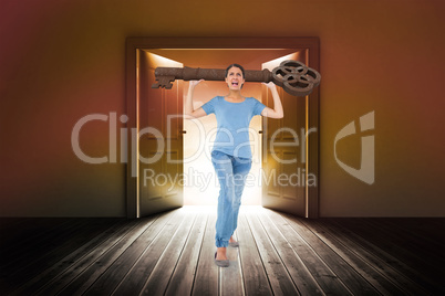 Composite image of annoyed brunette carrying large key