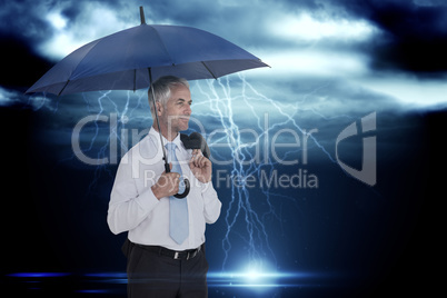 Composite image of happy businessman holding umbrella