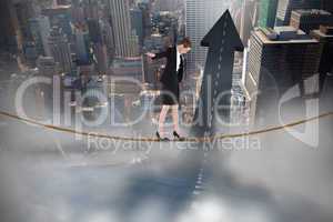 Composite image of businesswoman performing a balancing act