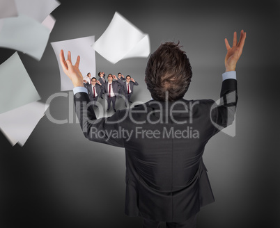 Composite image of gesturing businessman with tiny businessmen