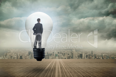 Composite image of thinking businessman in light bulb