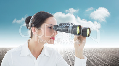 Composite image of business woman looking through binoculars