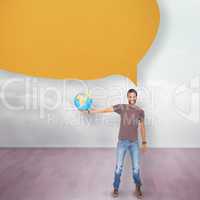 Composite image of handsome man holding out a globe with speech