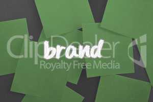 Brand against green paper strewn over black