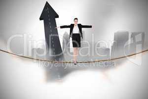 Composite image of businesswoman performing a balancing act